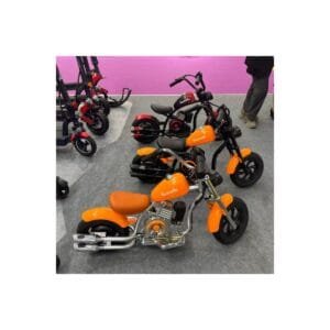 Orange and red Toumoto mini electric motorcycles with retro chopper design and chrome exhaust pipes displayed at an exhibition.